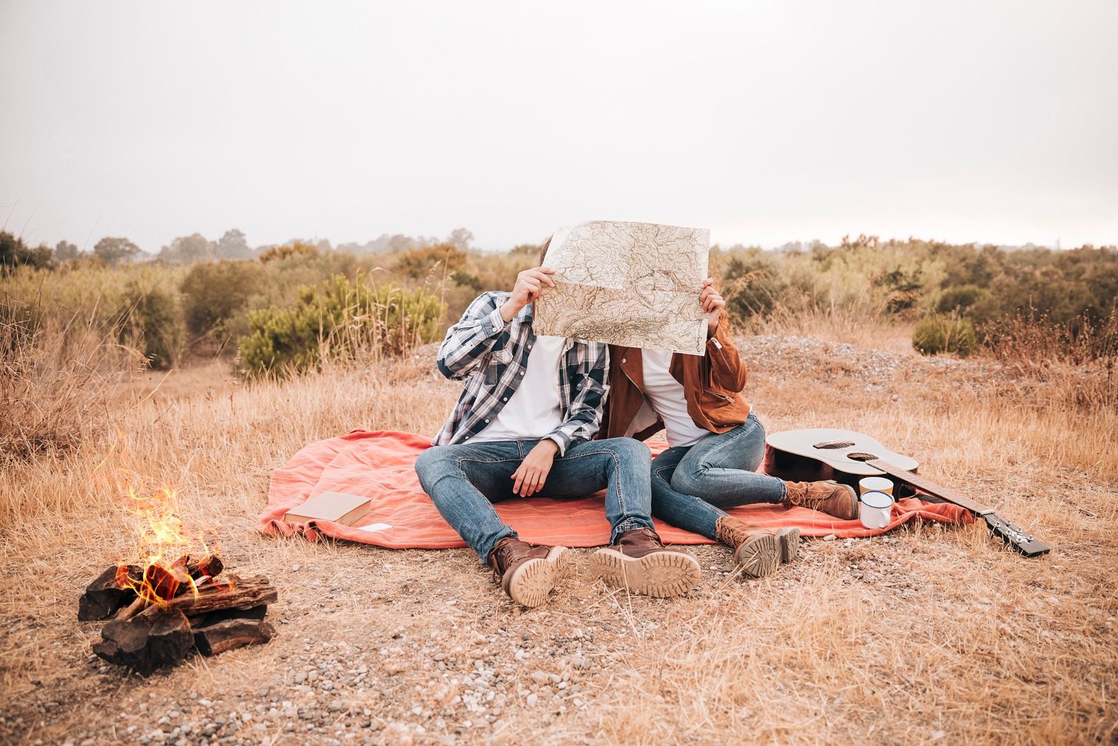 Two guests working out the day's route over a map beside the fire