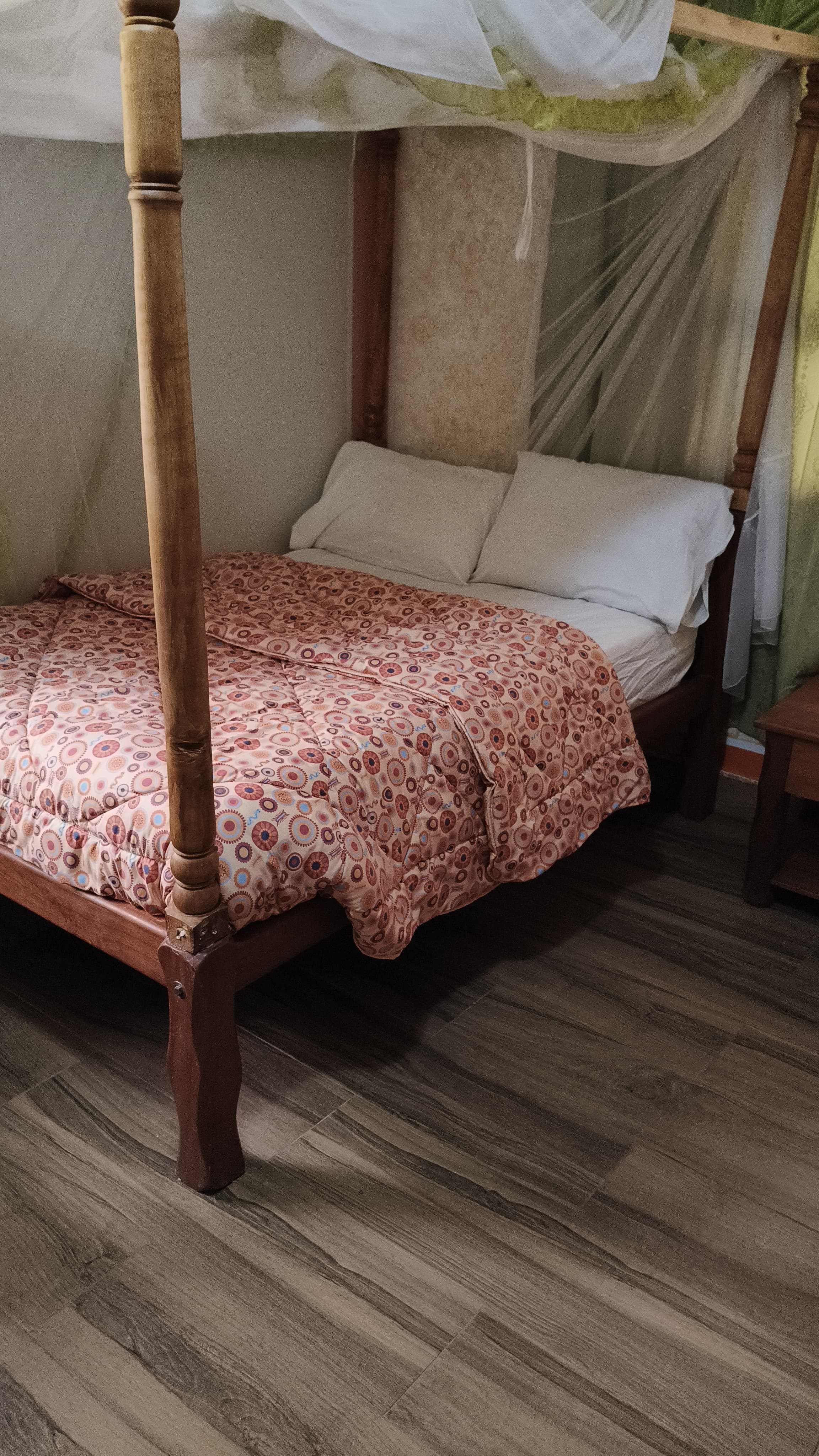 Guest house bedroom with a four-poster bed and mosquito net