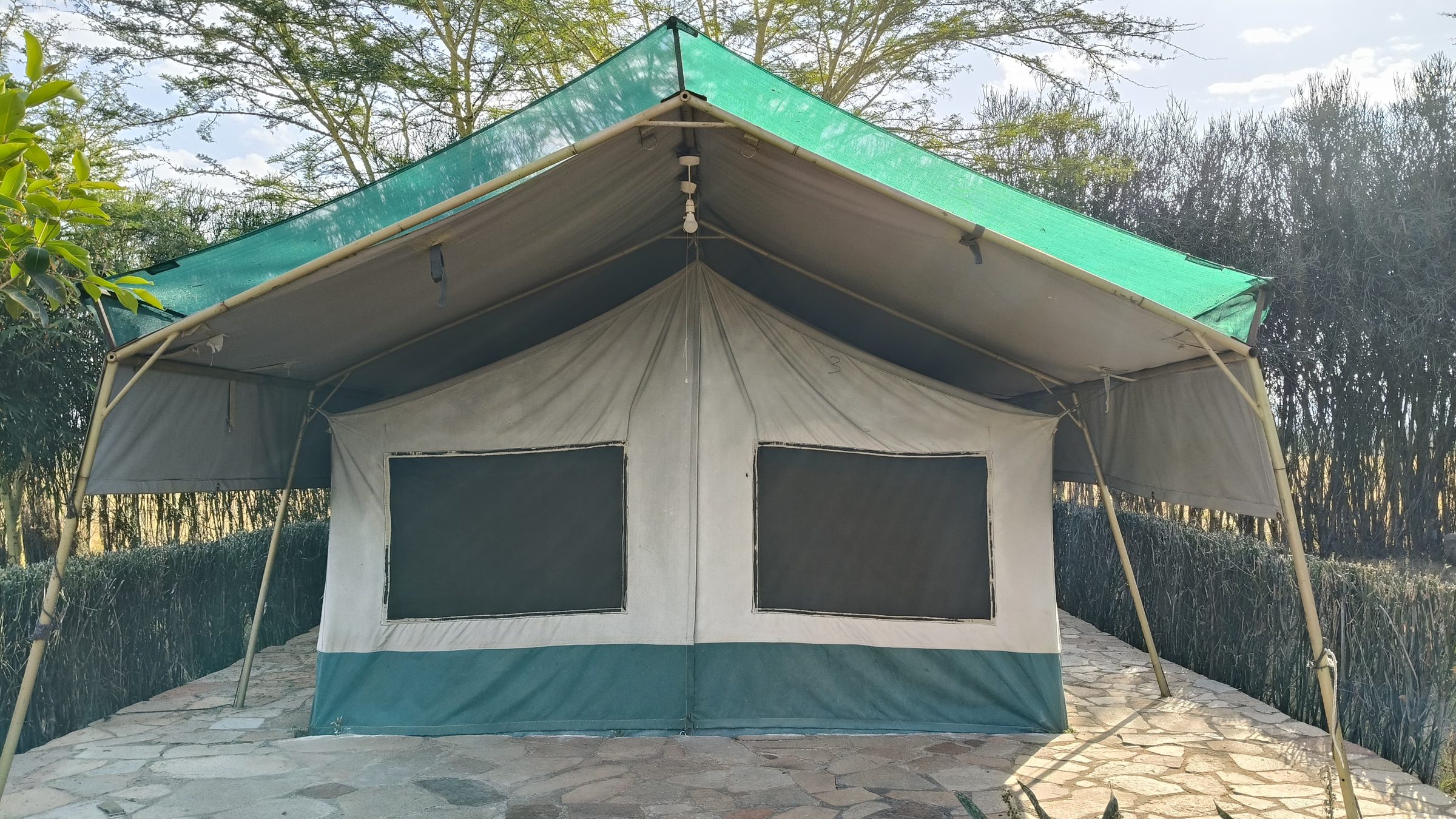 A classic canvas safari tent pitched under the trees